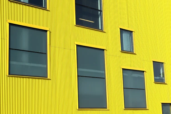 Windows of different sizes on  yellow  wall