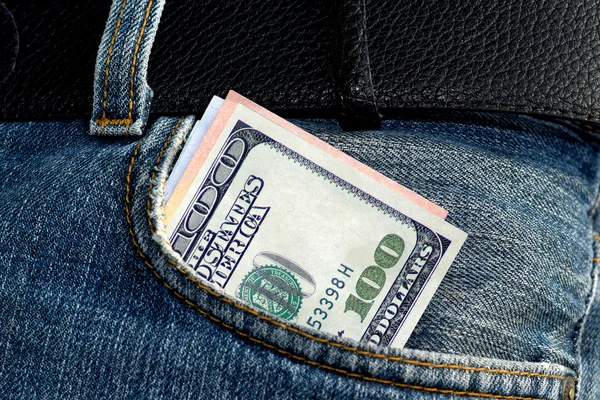 One hundred dollars bill sticking out of the blue jeans pocket