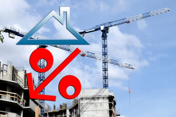 Red percent sign on the background of building a house .