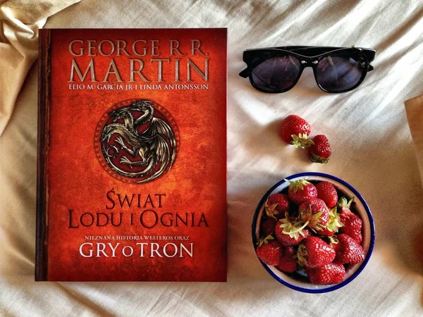 Strawberries, book \'Game of Thrones\' and sunglasses