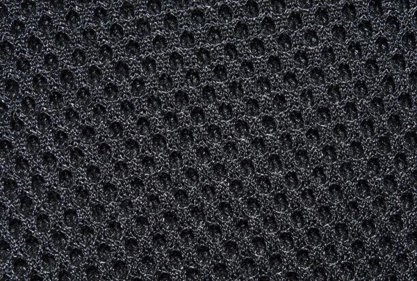 Black fabric texture with pattern, with sagging inside the ovals. The texture of the fabric. Closeup
