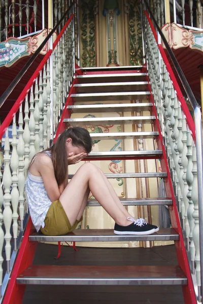 Sad little girl sitting on stairs