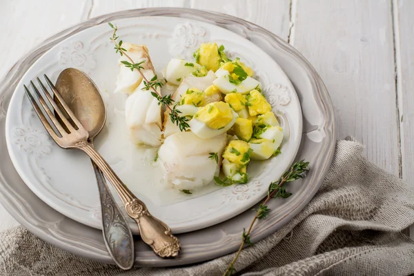 Boiled white fish cod with a sauce based on butter and boiled eggs