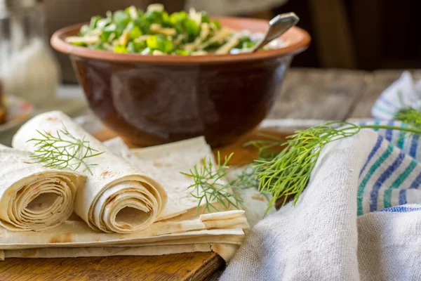 Fine homemade pita bread wrapped in a roll with fresh seasonal greens