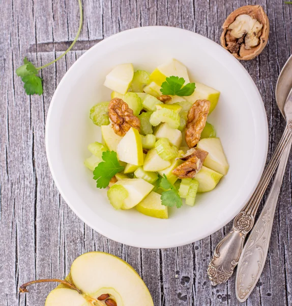 Light fresh spring salad with green apple, stem celery, walnuts