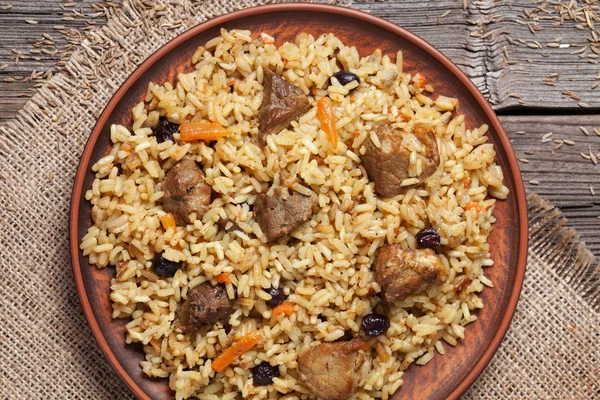 Dish of pilaf, national uzbek spicy meal with meat, rice, onion and garlic
