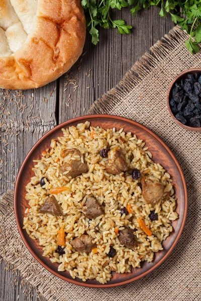 Plate of pilaf, traditional turkish spicy food with rice, fried meat, carrot onion and parsley