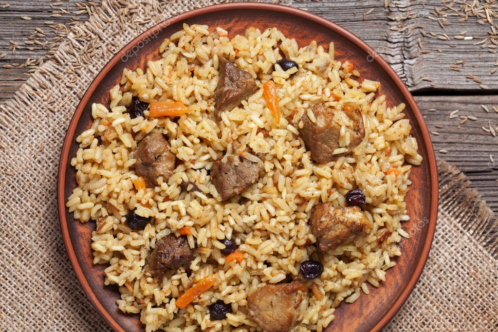 Dish of pilaf, national uzbek spicy meal with meat, rice, onion and