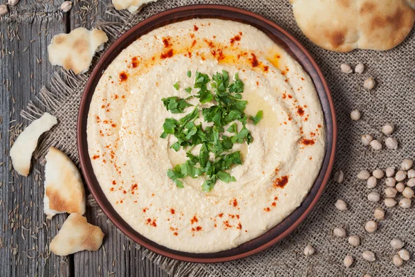 Bowl of hummus, creamy vegetarian food with chick-peas, paprika, olive oil and pita flatbread