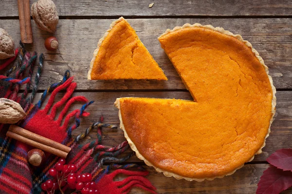 Sweet delicious natural pumpkin tart pie dessert sliced on vintage wooden table background. Autumn color composition.