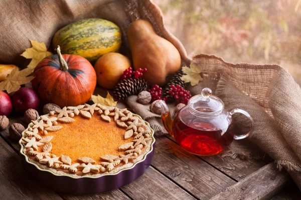 Traditional homemade pumpkin tart pie healthy sweet dessert recipe with tea. Halloween or thanksgiving holiday celebration meal. Autumn composition decoration and natural light. Vintage wooden