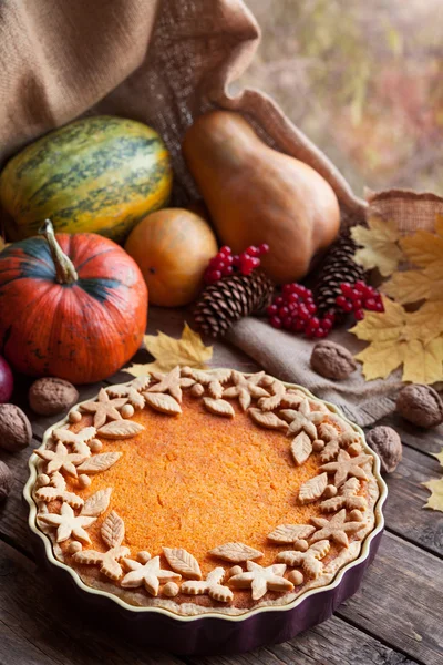 Homemade seasonal pumpkin tart pie with cute decoration on top recipe. Healthy organic pastry. Traditional thanksgiving day food. Autumn decorated composition, vintage wooden background.