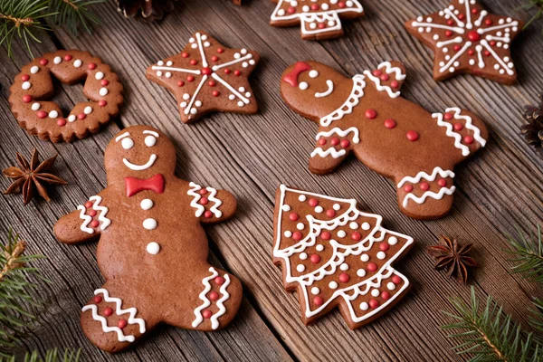 Gingerbread cookies man and woman couple christmas holiday composition with icing on vintage wooden table background. Traditional homemade dessert food recipe.