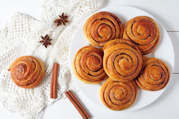 Cinnamon bun rolls christmas sweet dessert on white vintage table. Traditional swedish kanelbullar baked pastry.