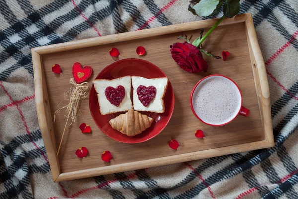 Valentines day breakfast in bed sweet romantic present, red rose flower. Two toasts with jam and hot chocolate.