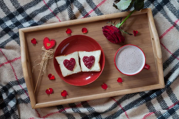 Breakfast in bed for Valentines Day. Romantic present with rose flower, toasts and hot chocolate. Top view.