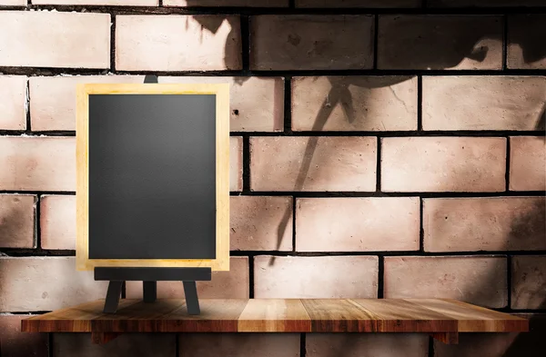 Empty blackboard on wooden at brick wall