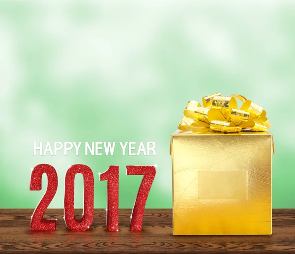 Happy new year 2017 wood number and golden present on brown wood