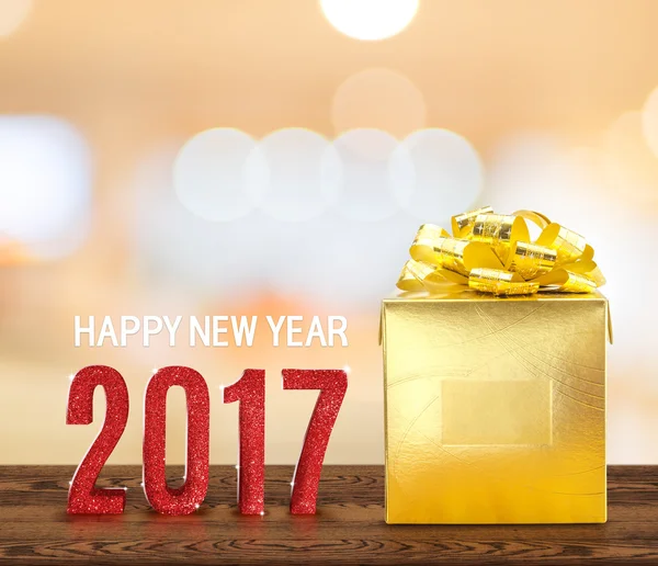 Happy new year 2017 wood number and golden present on brown wood