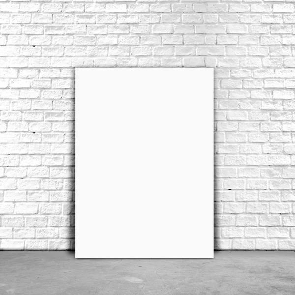 Blank Poster paper standing next to a white brick wall