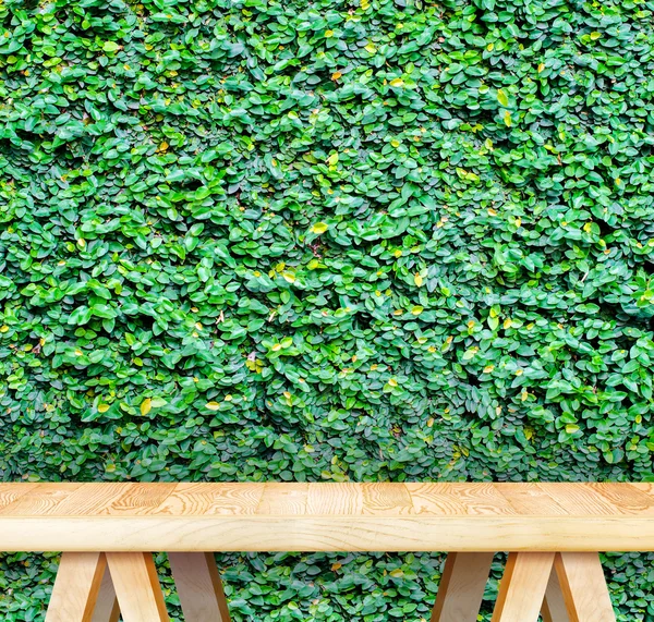 Wood table at green hedge