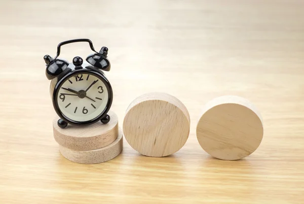 Black alarm clock  on wooden pieces