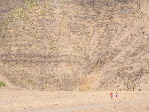 Two Maasai children walking