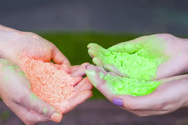 Female hands holding  color powder