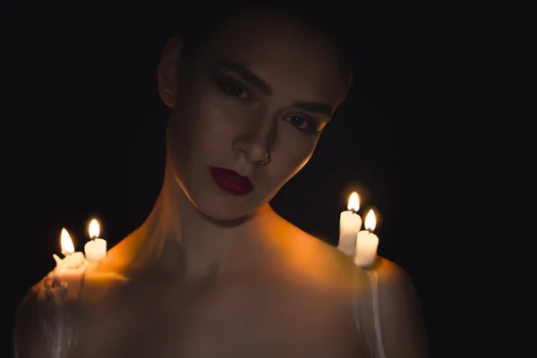 Pretty woman with candles on her shoulders