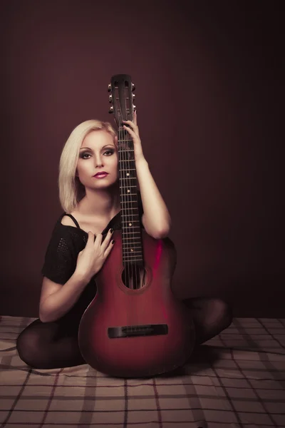 Young blonde woman with a guitar