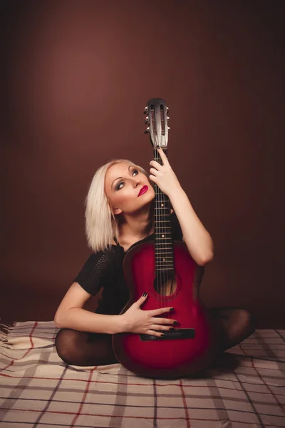Young blonde woman with guitar