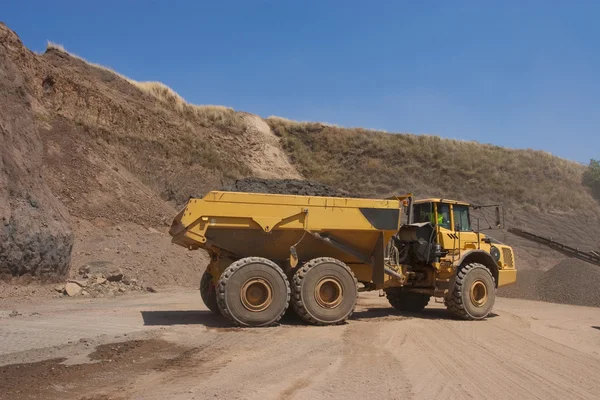 Truck and bulldozer work in the quarry