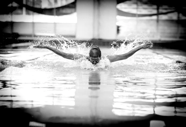 Young athletic man with butterfly swimming technique.