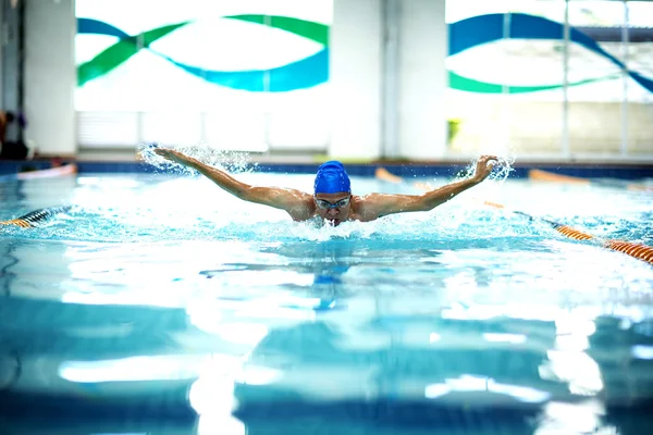 Young athletic man with butterfly swimming technique.