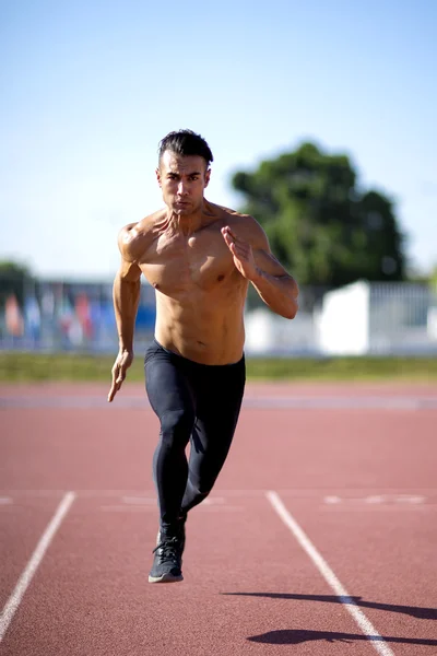 Young muscular man ready to start a track meet.