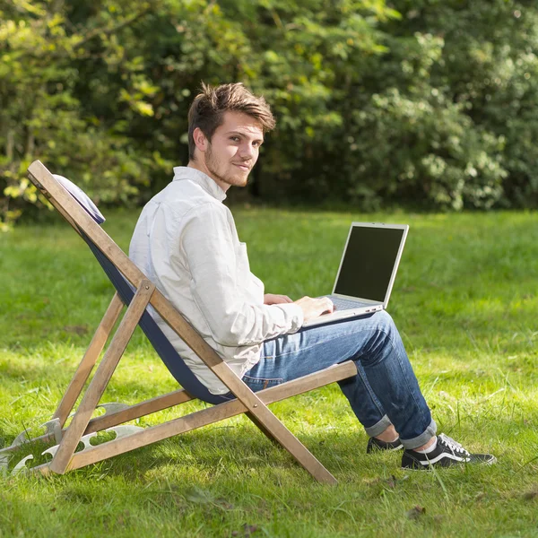 Portrait of young man on profile sitting with laptop computer