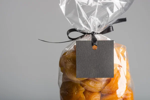 Closeup on transparent bag of dried apricots with black blank label