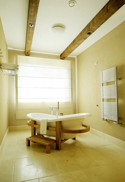 Beautiful white tub against the window. bath stands on a wooden