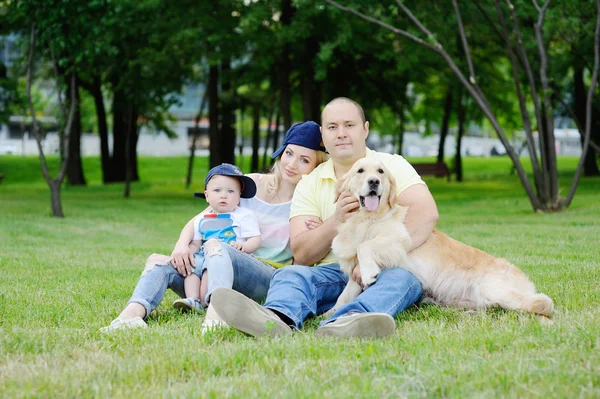 Family with a dog retriever on the grass