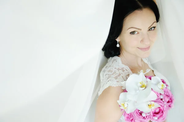 Beautiful bride with a wedding bouquet of orchids