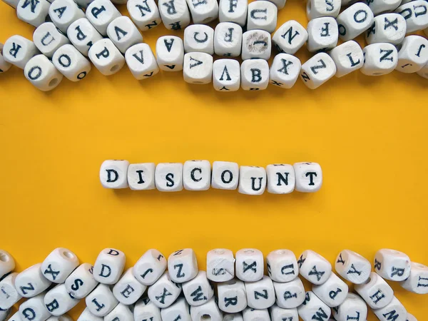 Word Discount of small white cubes on a yellow background