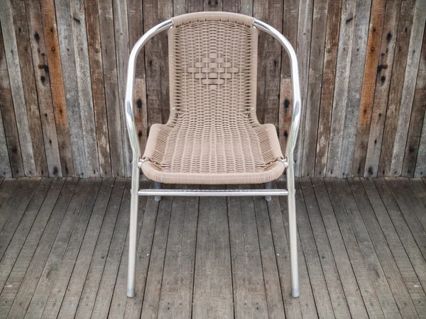 Metal chair with woven seat on old wooden floor