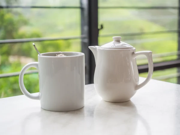 White teapot and tea cup on the table at Boh Tea Plantation