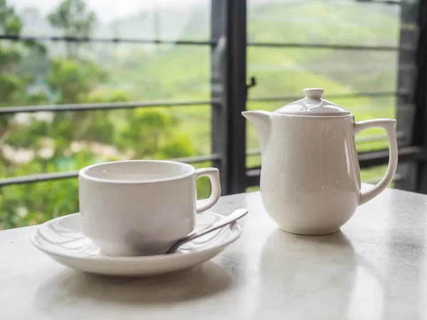 White teapot and tea cup on the table at Boh Tea Plantation