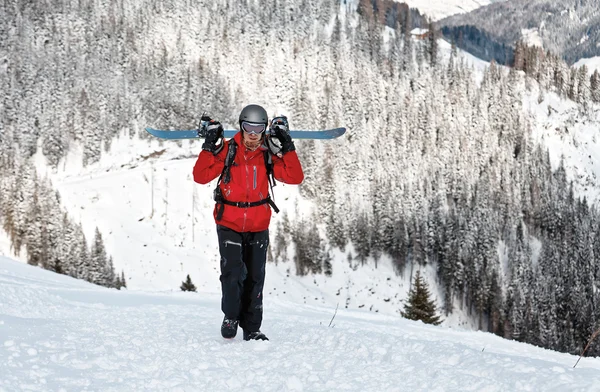 Lonely snowboarder walking with the board