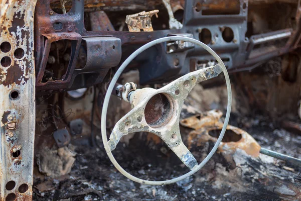 Burnt car interior with steering wheel after the accident