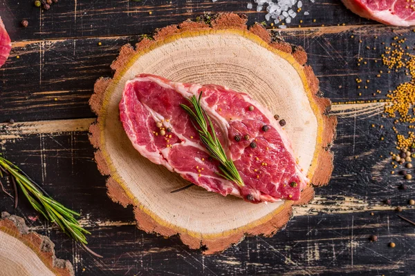 Raw juicy meat steak on dark wooden background ready to roasting