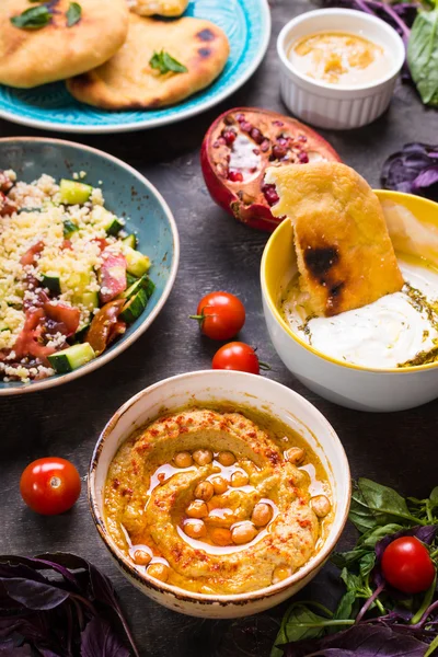 Table served with middle eastern vegetarian dishes. Hummus, tahi