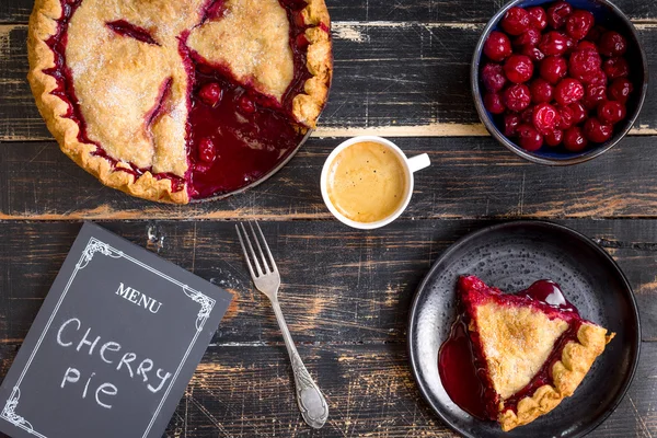 Cherry pie, cup of coffee and menu chalkboard