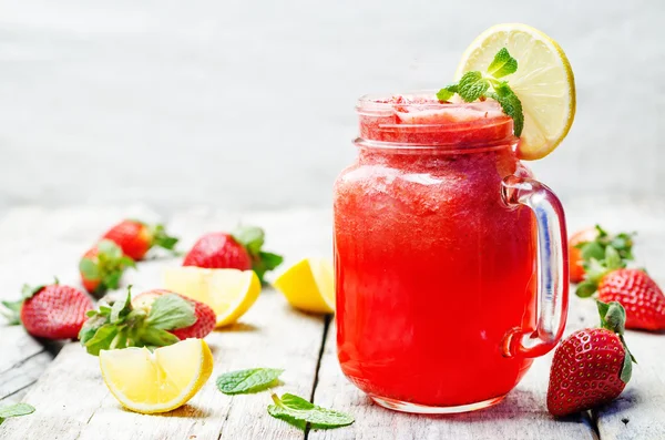 Strawberry lemonade on a white wooden background
